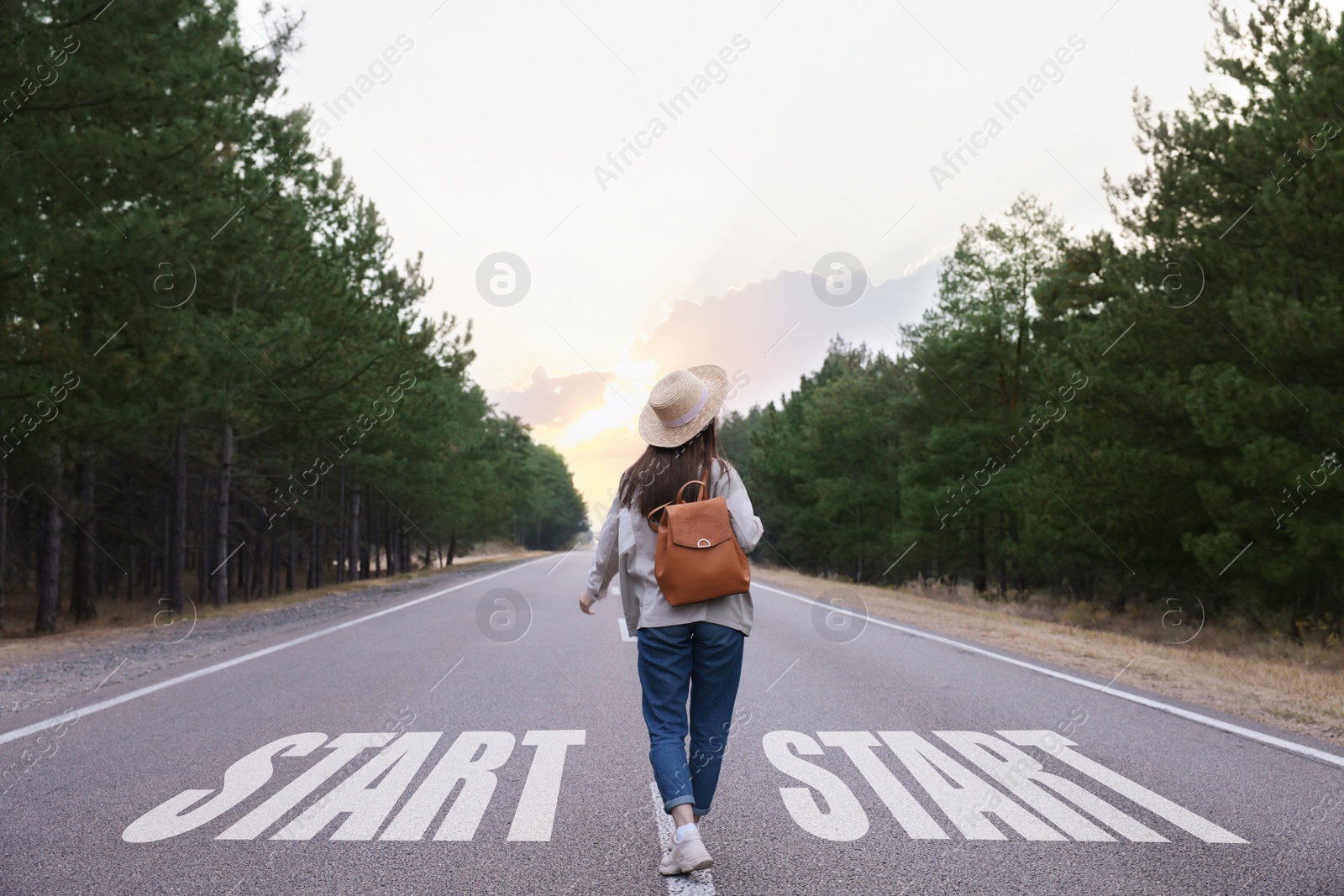 Image of Young woman walking along road, back view