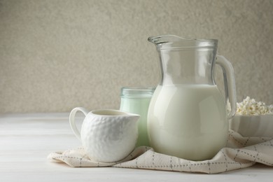 Photo of Lactose free dairy products on white wooden table, space for text