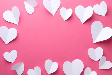 Photo of Frame of beautiful white paper hearts on pink background, flat lay. Space for text