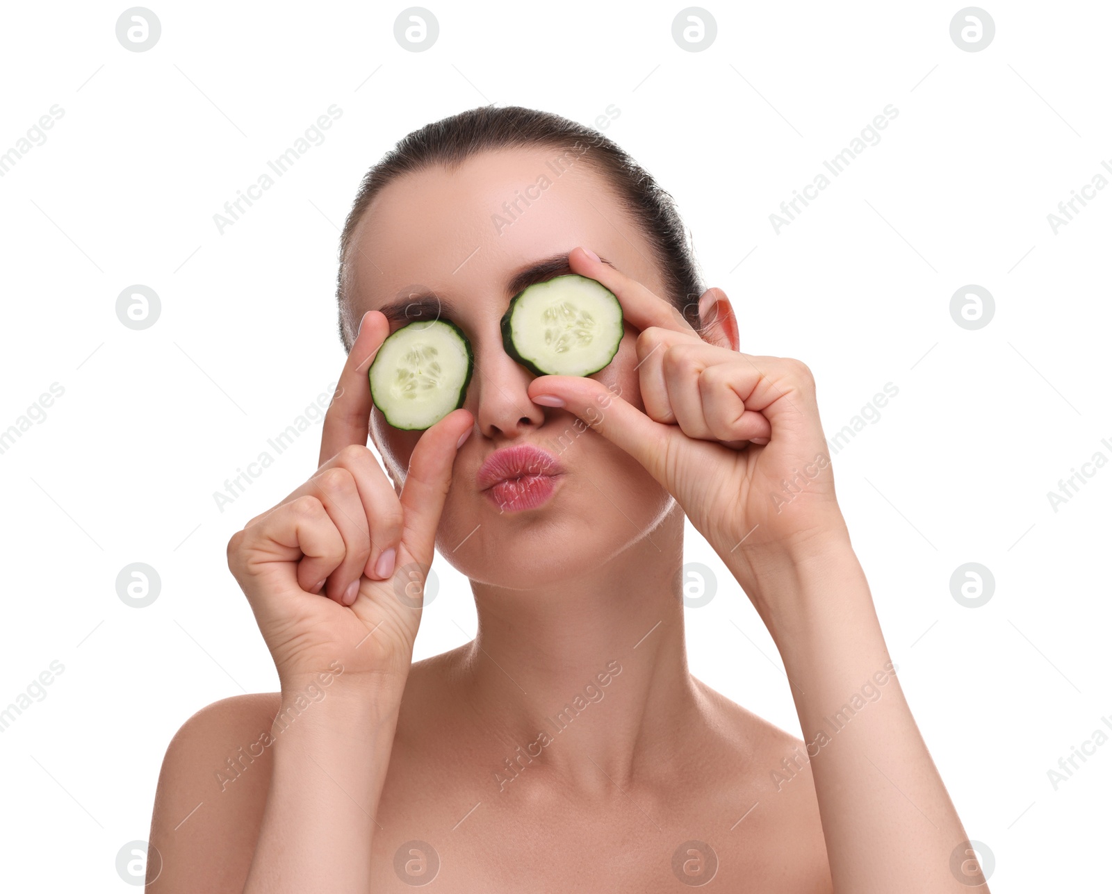 Photo of Beautiful woman covering eyes with pieces of cucumber and blowing kiss on white background