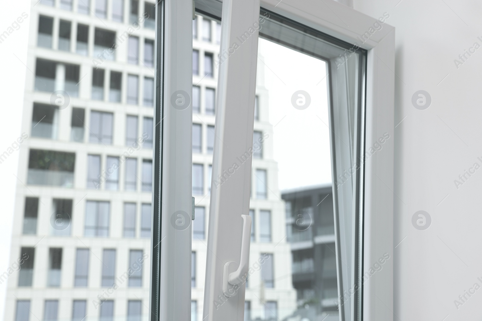 Photo of Open window with white plastic frame indoors