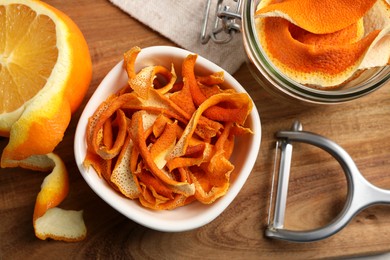 Dry orange peels and fresh fruit on wooden board, flat lay