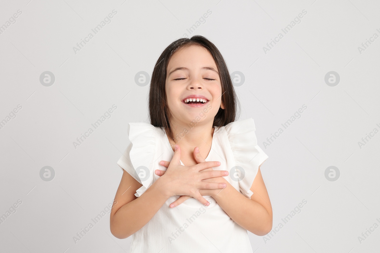 Photo of Portrait of cute little girl on light grey background