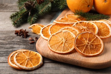 Photo of Dry orange slices, anise stars and fir tree branches on wooden table, closeup