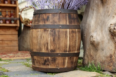 Photo of Traditional wooden barrel and decorative branches outdoors