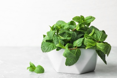 Photo of Bowl with fresh green mint on table. Space for text