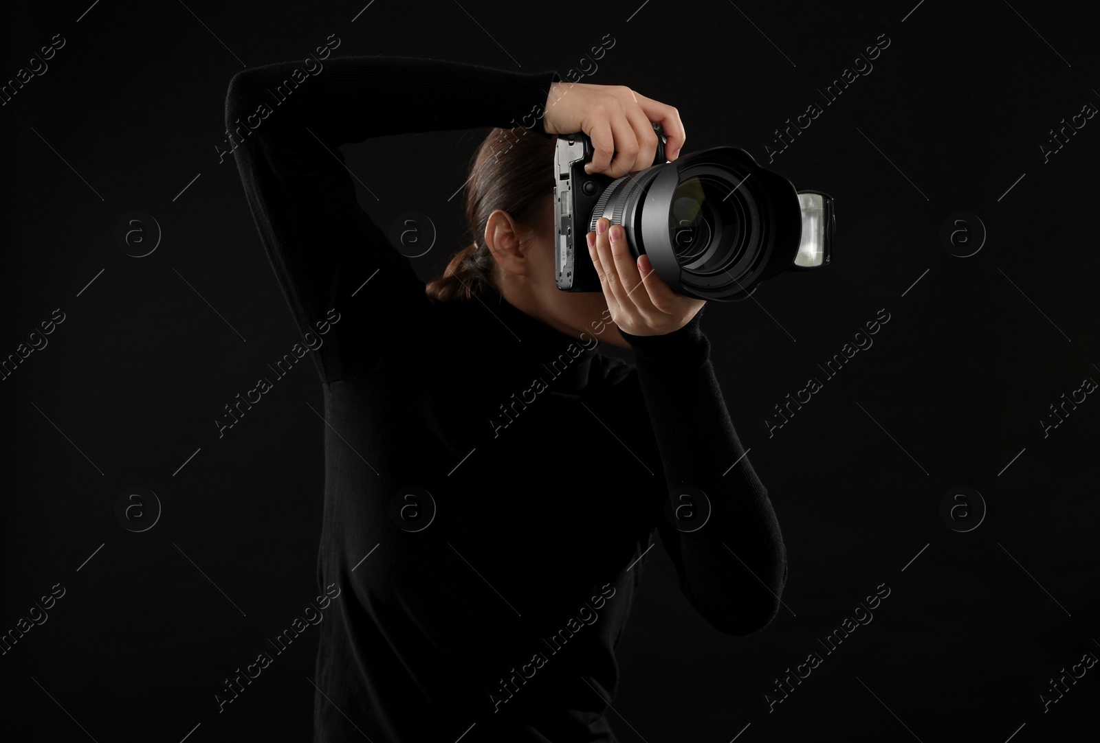 Photo of Professional photographer taking picture on black background