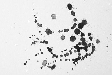 Photo of Blots of black ink on white background, flat lay