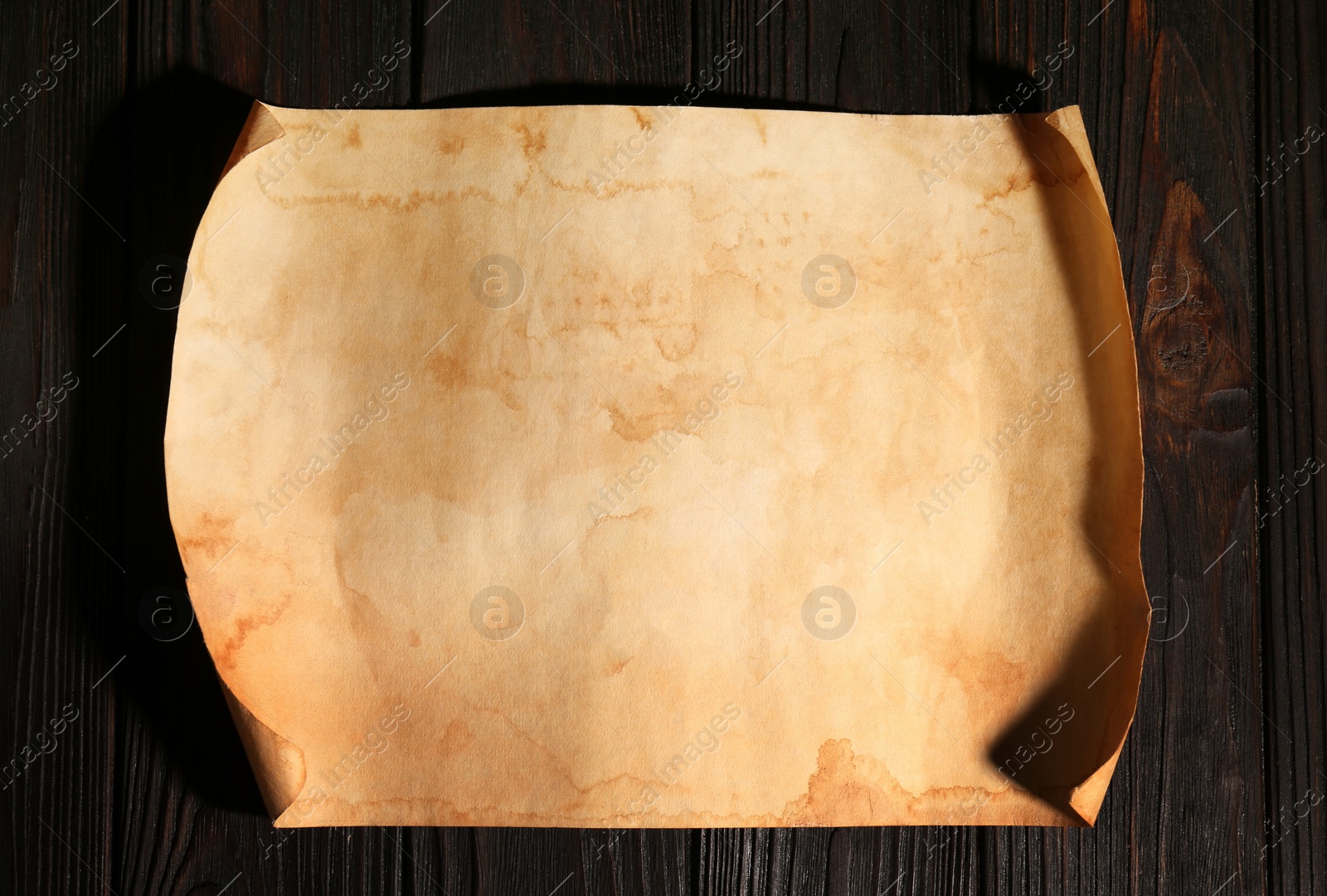 Photo of Sheet of old parchment paper on wooden table, top view