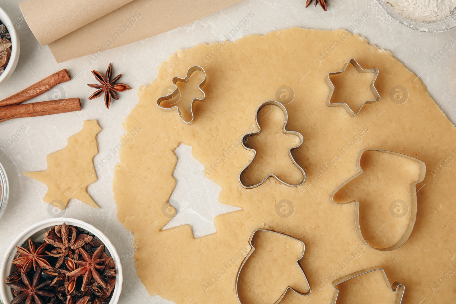 Photo of Flat lay composition with dough and cookie cutters on light table. Christmas biscuits