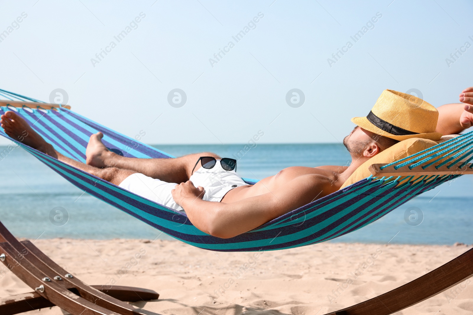 Photo of Young man relaxing in hammock on beach