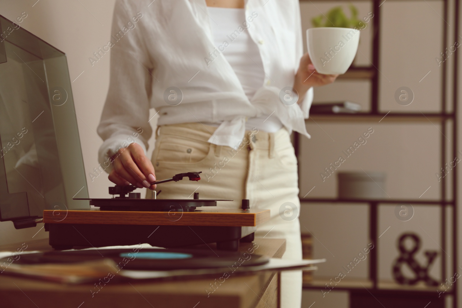 Photo of Woman using turntable at home, closeup view