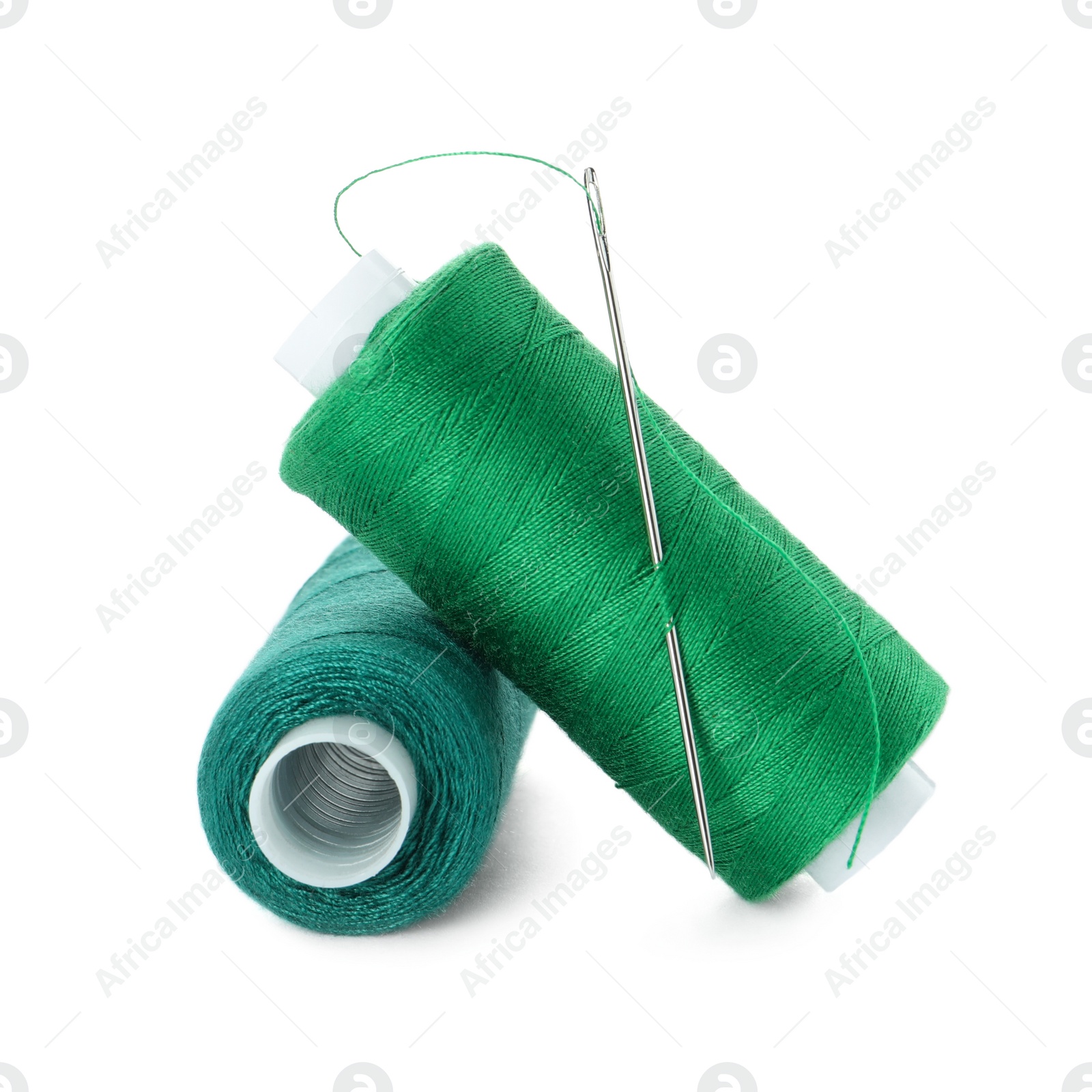 Photo of Different colorful sewing threads and needle on white background