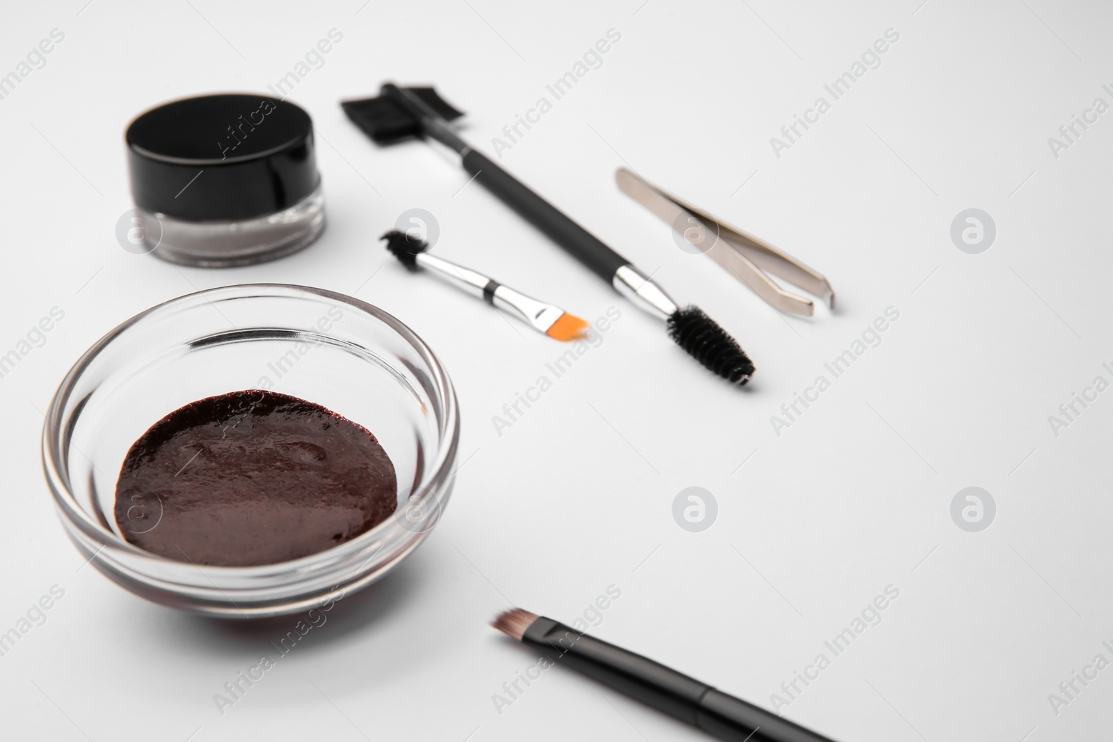 Photo of Eyebrow henna and professional tools on white background, closeup. Space for text