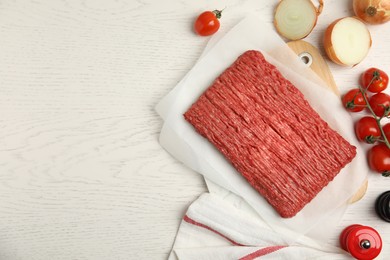 Photo of Raw fresh minced meat and other ingredients on white wooden table, flat lay. Space for text