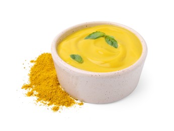 Bowl with tasty curry sauce, powder and basil leaves isolated on white