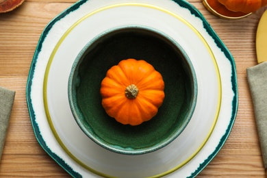 Autumn table setting with pumpkin on wooden background, flat lay