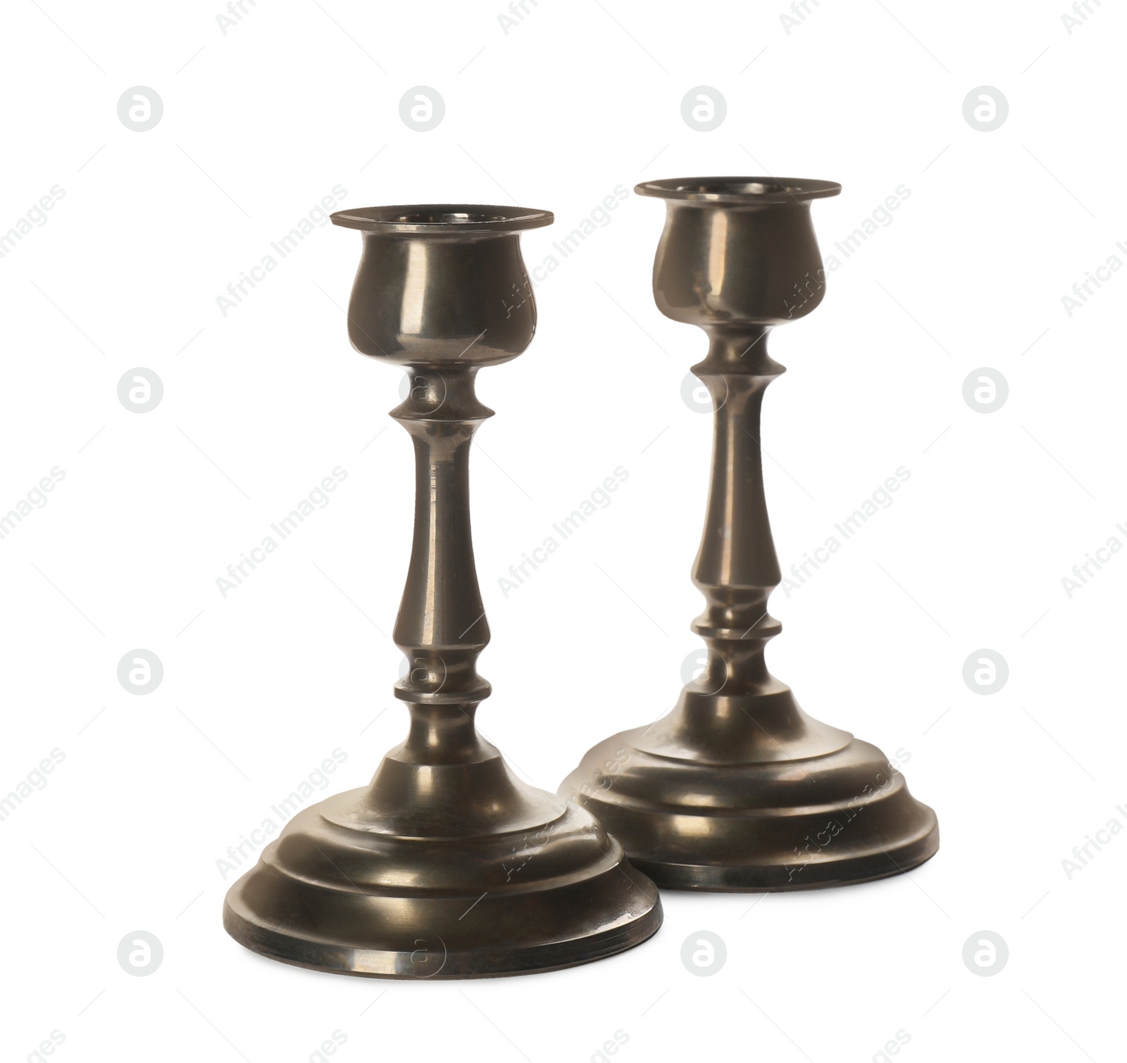 Photo of Two vintage metal candlesticks on white background