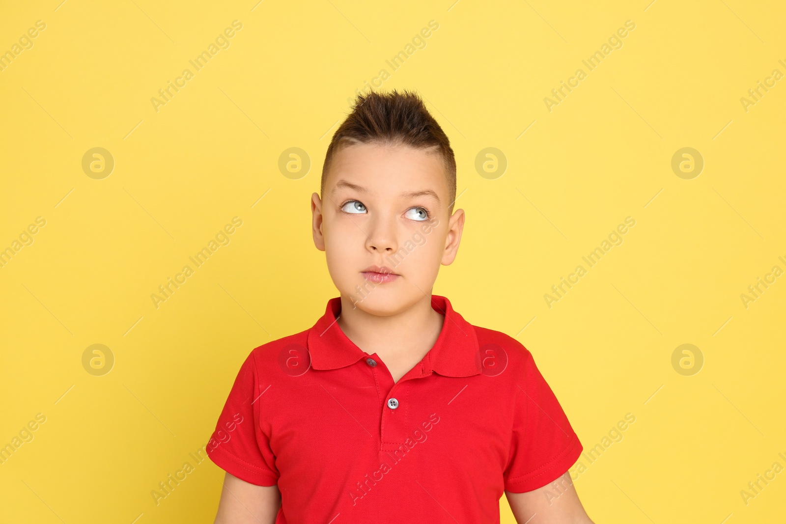 Photo of Portrait of emotional little boy on yellow background