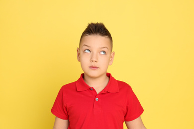 Portrait of emotional little boy on yellow background