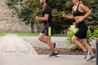 Photo of Healthy lifestyle. Couple running in park, closeup with space for text