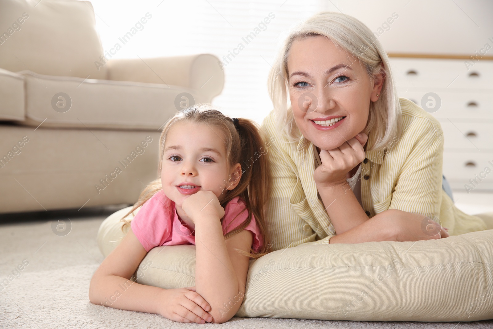 Photo of Mature woman with her little granddaughter at home