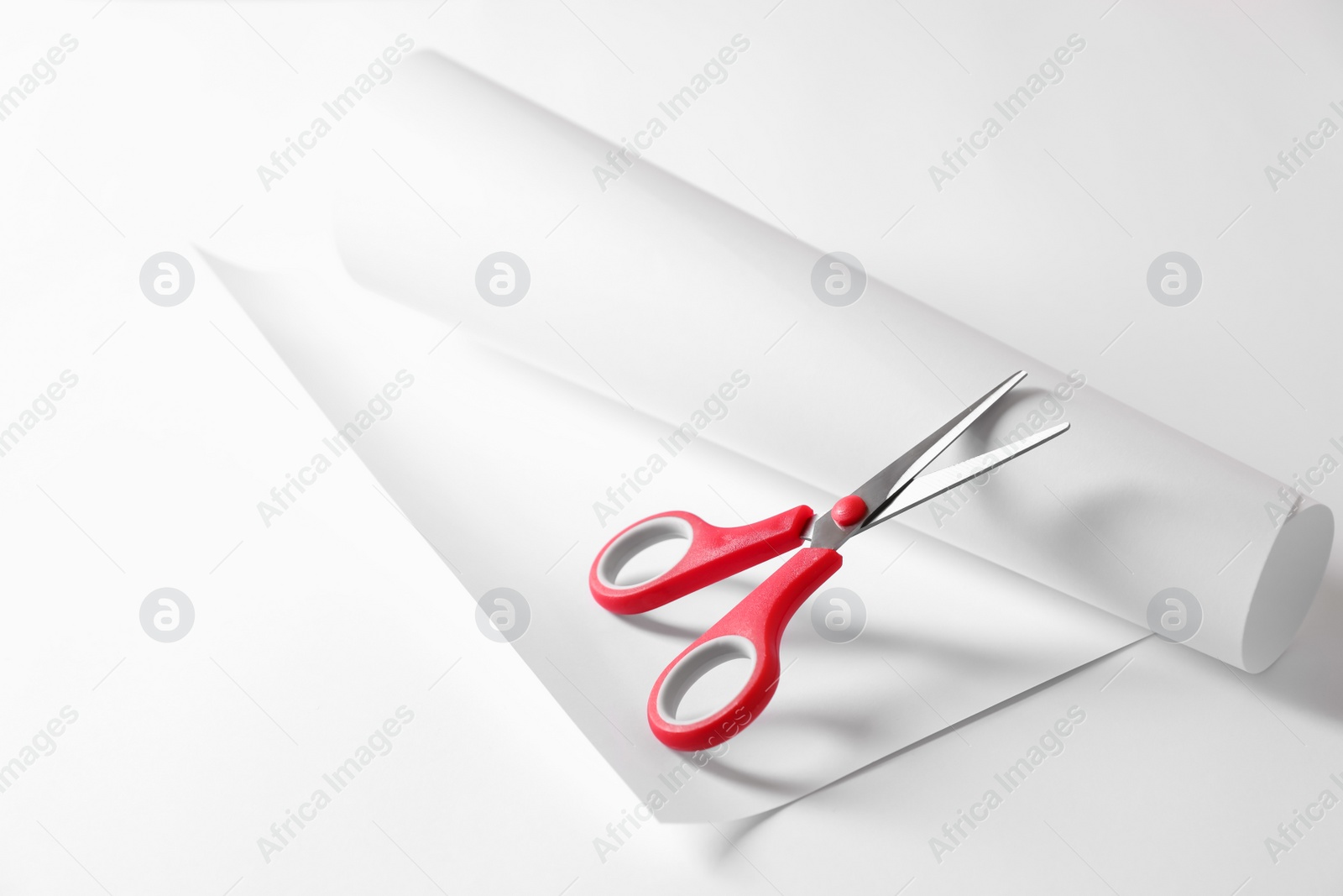 Photo of Red scissors and paper on white background. Space for text