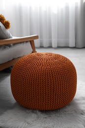Stylish knitted pouf on floor in room. Interior design