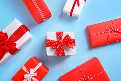 Photo of Beautifully wrapped gift boxes on color background, top view