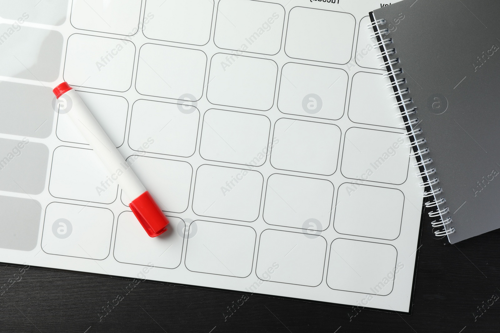 Photo of Timetable. Planner, felt pen and notebook on black wooden table, top view