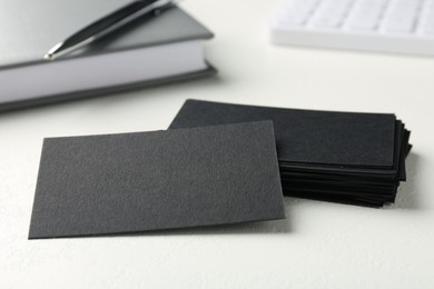 Photo of Blank black business cards on white table, closeup. Mockup for design