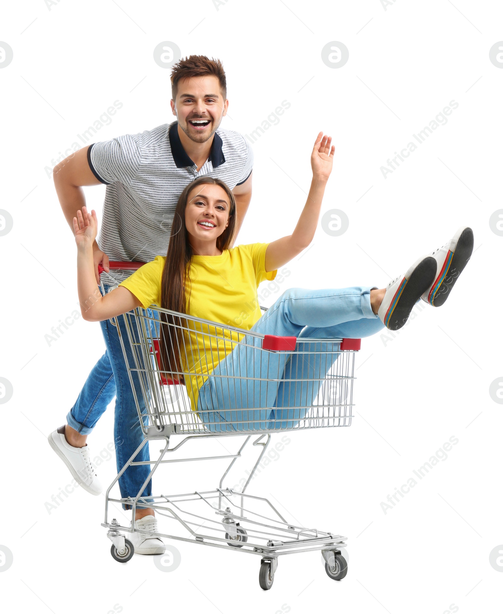 Photo of Young couple with shopping cart on white background