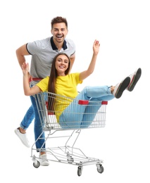 Young couple with shopping cart on white background