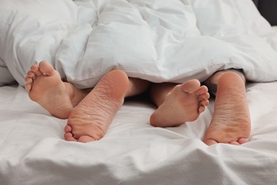 Photo of Passionate couple having sex on bed, closeup of legs