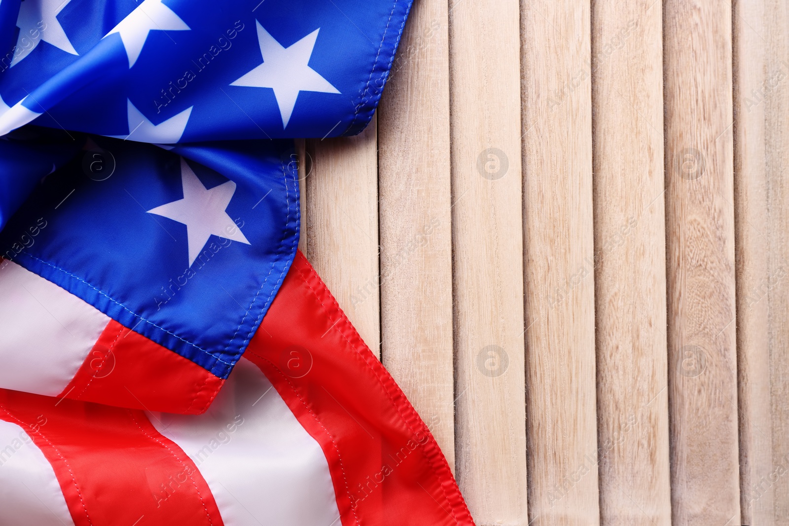 Photo of American flag on wooden background with space for text, top view