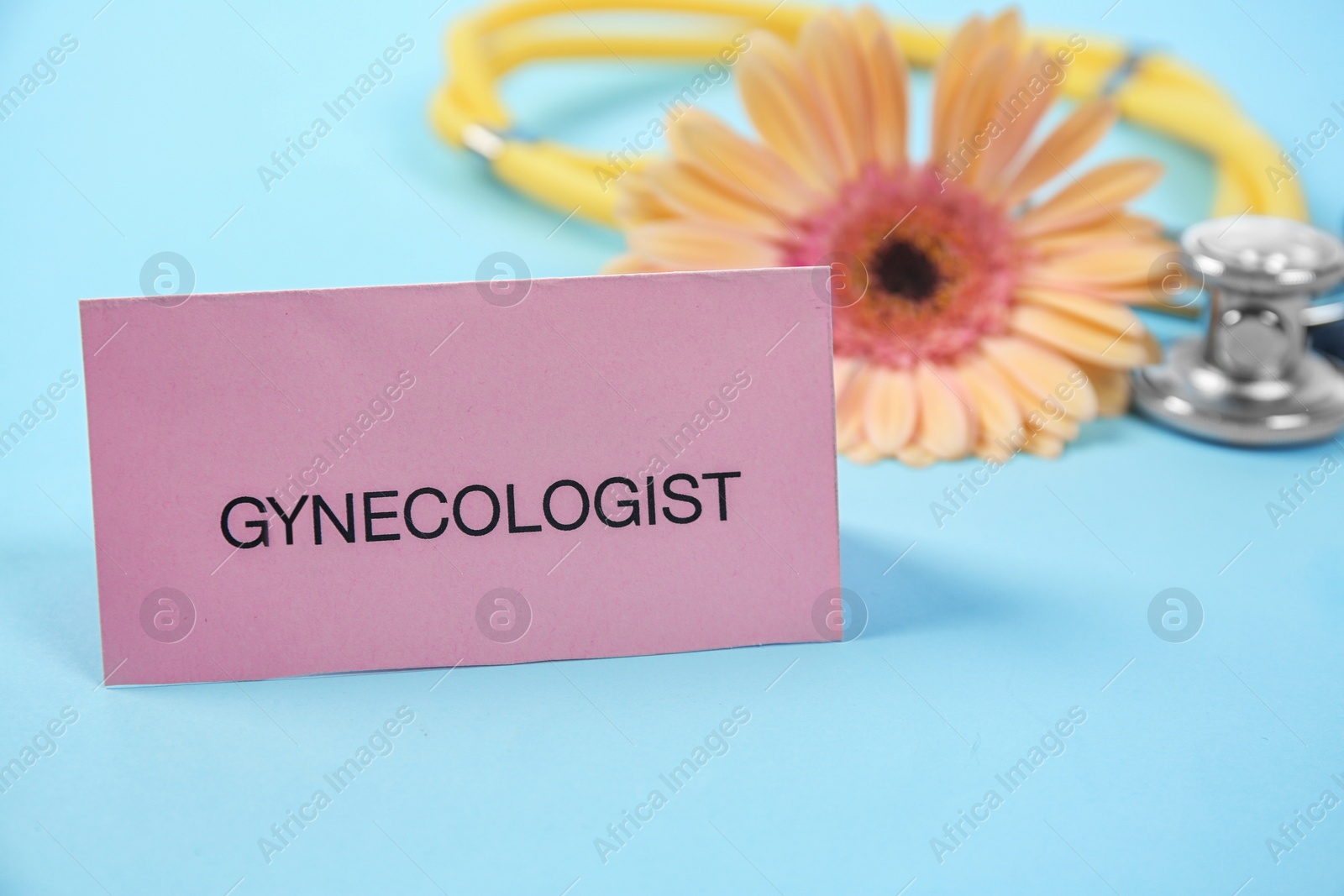 Photo of Composition with card, stethoscope and flower on color background. Gynecological checkup