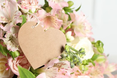 Photo of Happy Mother's Day. Beautiful flowers with blank heart shaped card on light background, closeup