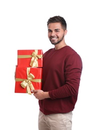 Happy young man holding Christmas gifts on white background