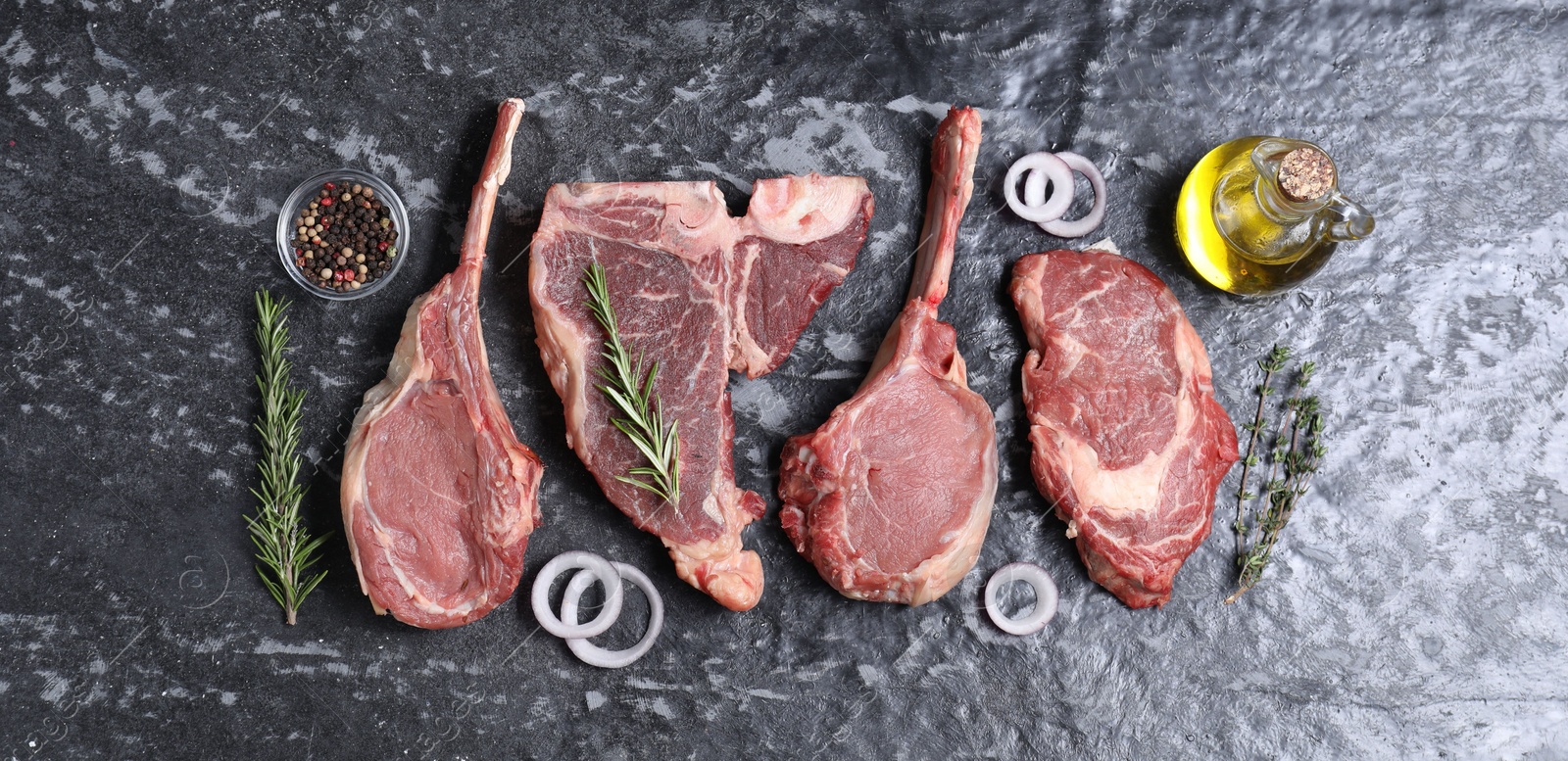 Photo of Fresh raw beef cuts and different spices on grey textured table, flat lay