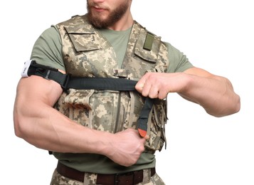 Photo of Soldier in military uniform applying medical tourniquet on arm against white background, closeup