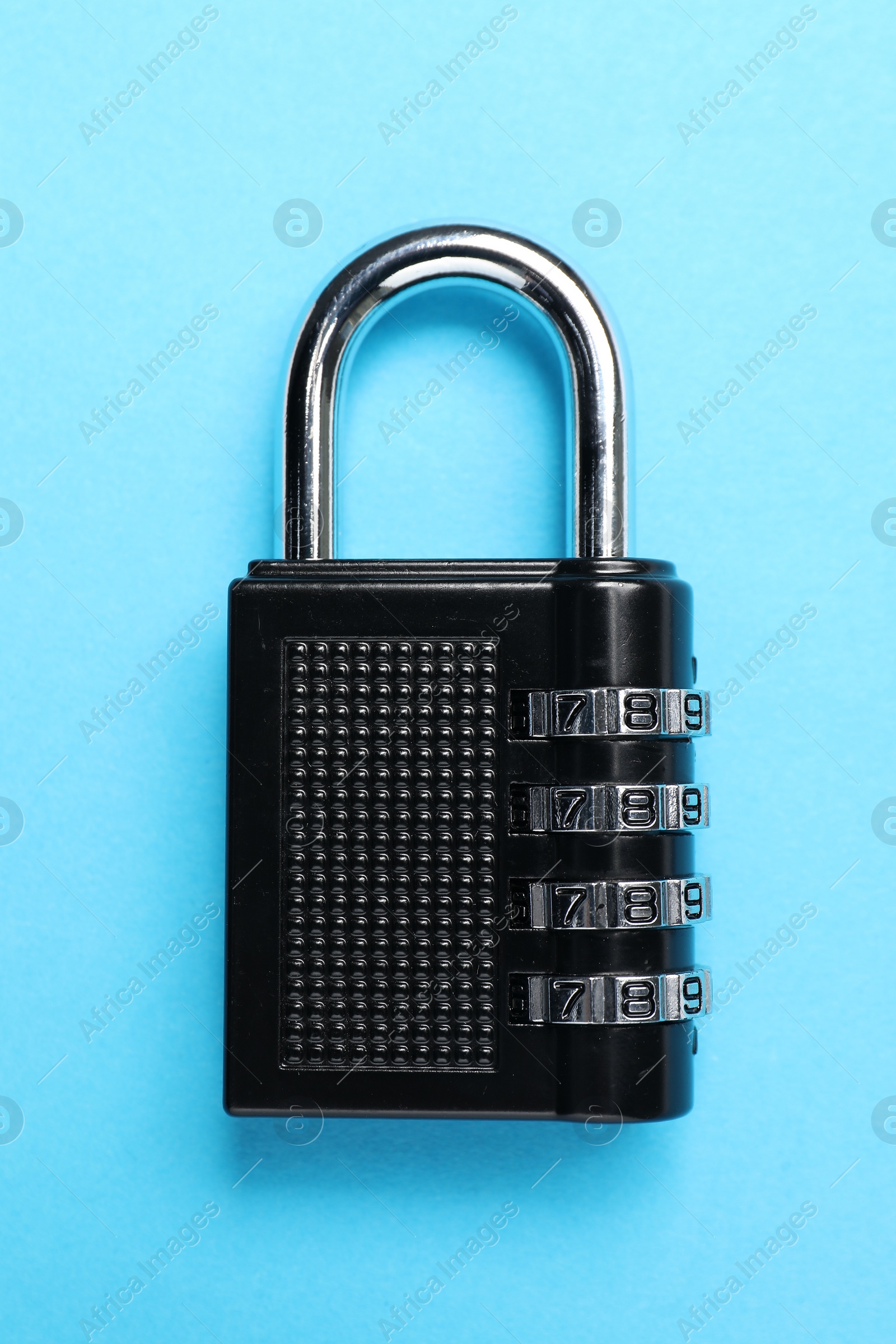 Photo of Steel combination padlock on light blue background, top view