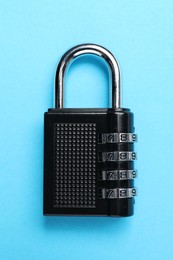 Steel combination padlock on light blue background, top view