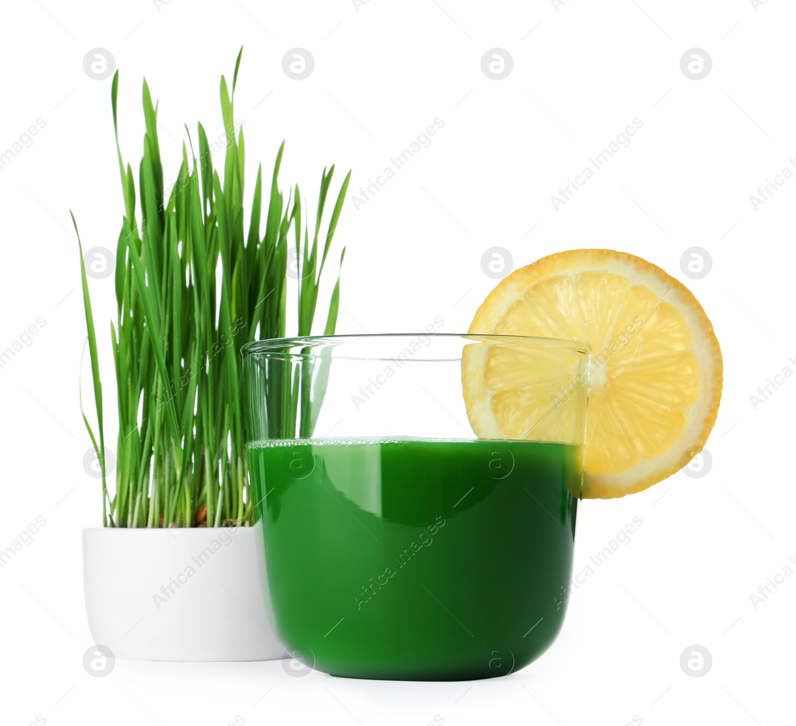 Glass of wheat grass juice served with slice of lemon and sprouts on white background Photo of Glass of wheat grass juice served with slice of lemon and sprouts on white background