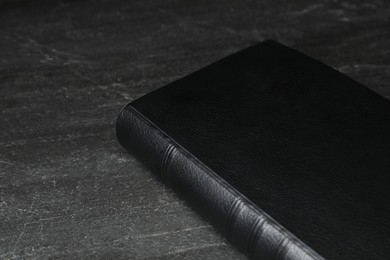 Bible on black table, closeup. Christian religious book