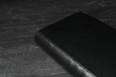 Photo of Bible on black table, closeup. Christian religious book