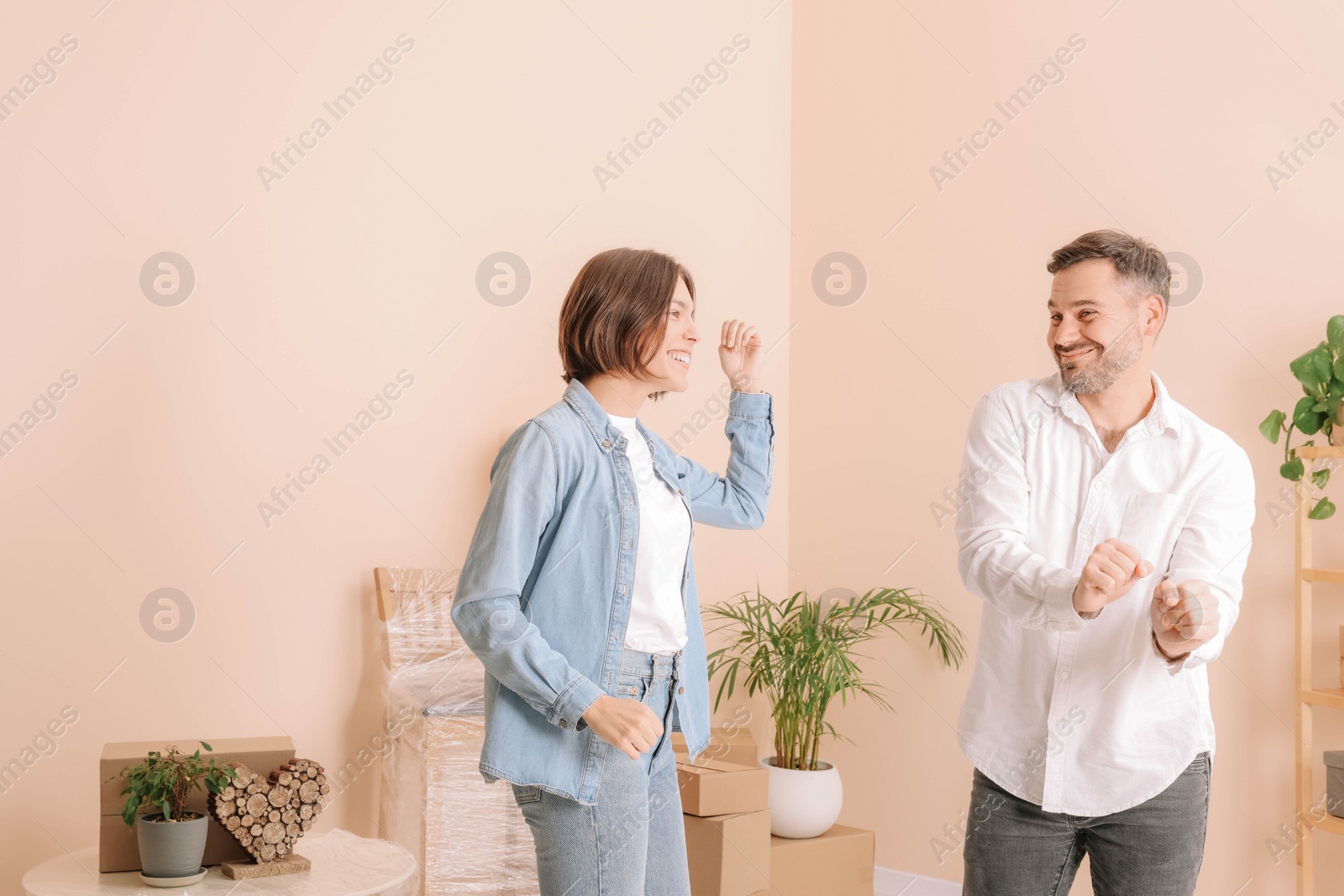 Photo of Happy couple having fun in new apartment. Moving day