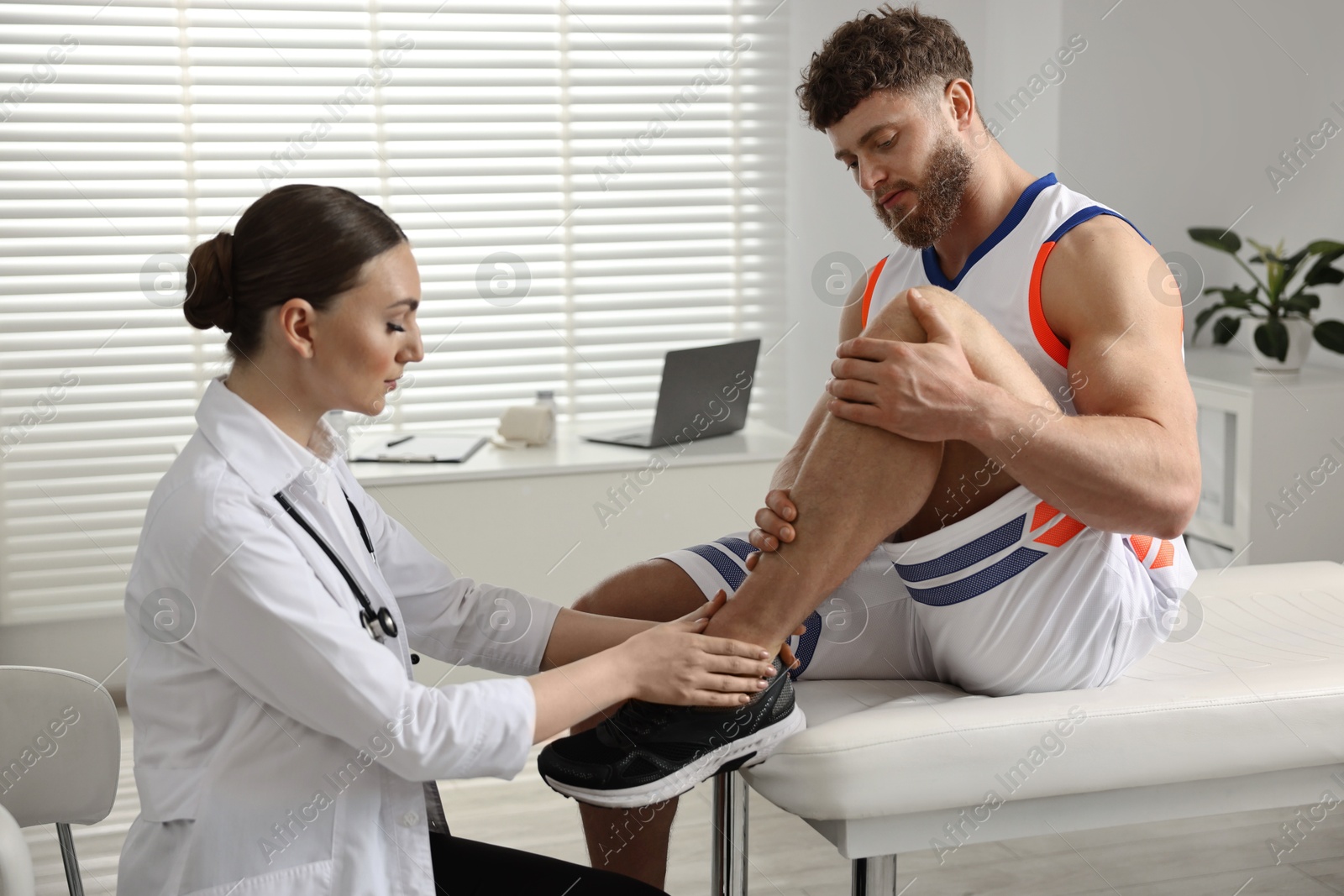 Photo of Sports injury. Doctor examining patient's leg in hospital