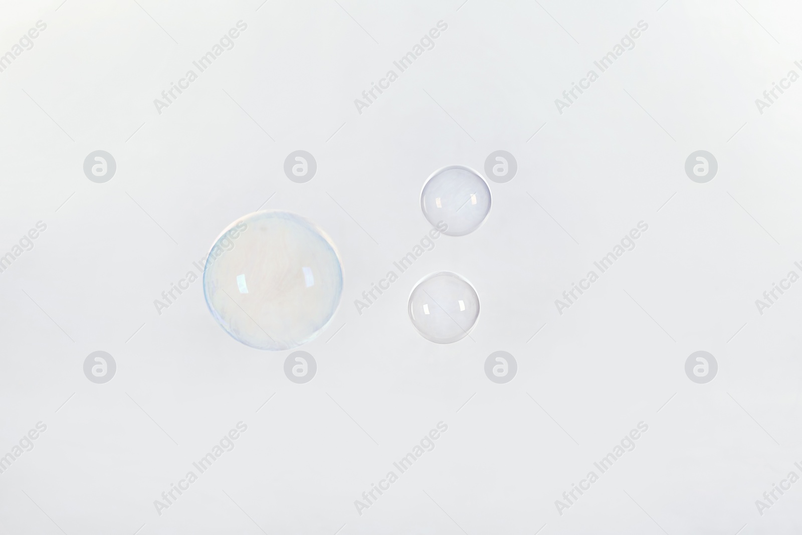 Photo of Beautiful translucent soap bubbles on light background. Space for text