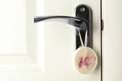 Photo of Scented sachet with flowers hanging on door handle