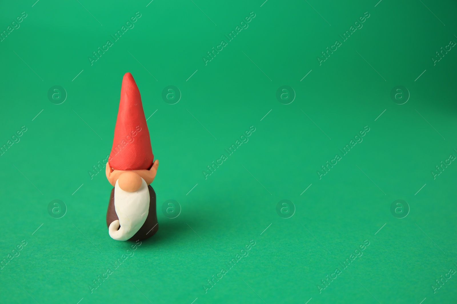 Photo of Dwarf made from plasticine on green background, space for text. Children's handmade ideas